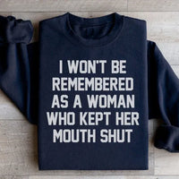 Black sweatshirt showing the phrase 'I Won't Be Remembered As A Woman Who Kept Her Mouth Shut' in white font.