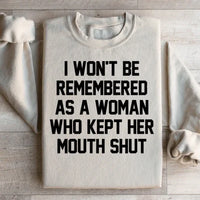 Sand-colored sweatshirt featuring the statement 'I Won't Be Remembered As A Woman Who Kept Her Mouth Shut' in white text.