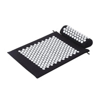 Black acupressure mat with tiny plastic spikes for pain relief and stress reduction