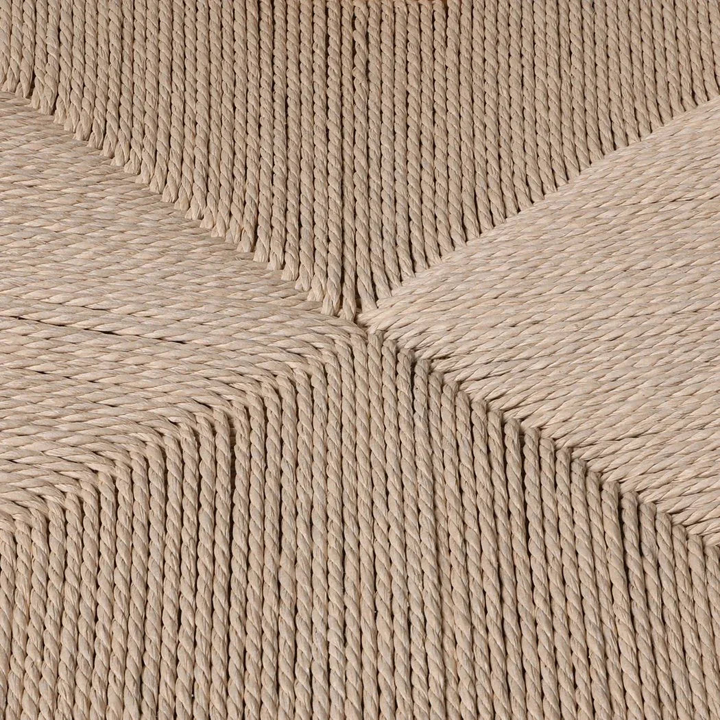 Side profile of a wood framed dining chair featuring a textured rattan seat.