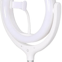 Woman using 12-inch LED ring light and phone holder tripod to take a selfie indoors.