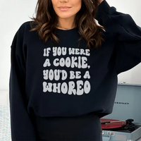 Front view of peach sweatshirt with If You Were A Cookie You'd Be A Whoreo text in bold letters.