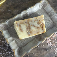 Stack of oat and honey soap bars with visible oats and honey golden hues.