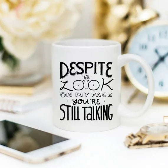 Coffee mug with funny quote placed on a wooden surface with a blurred background