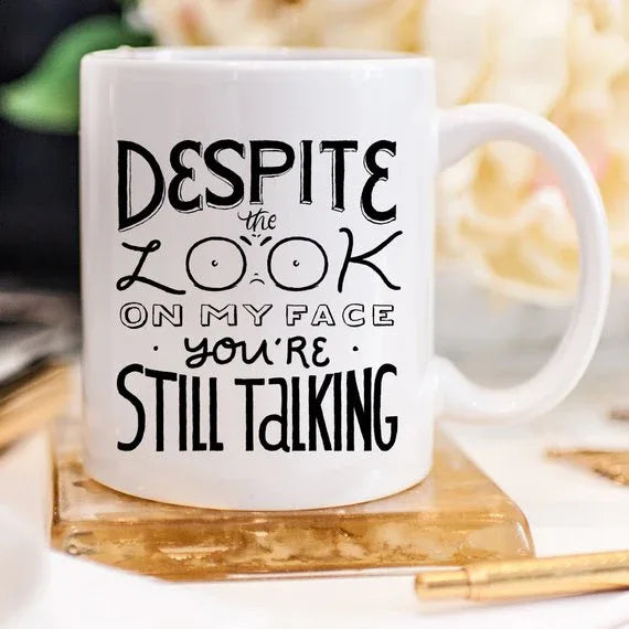 Side view of white ceramic mug featuring a funny phrase in black lettering