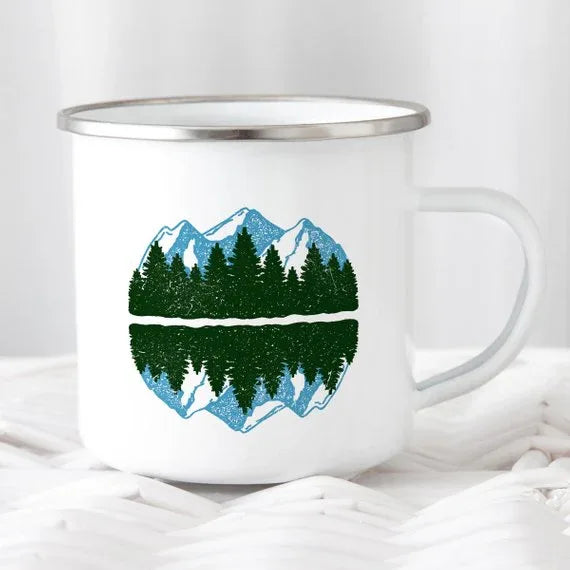 Close-up of enamel mug with mountain graphic and 'Wanderlust' text, stainless steel rim visible.