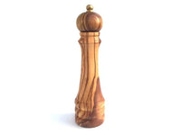 Wooden pepper mill with a clear metallic top, shown in natural lighting.