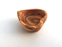 Mini heart-shaped dish with various jewelry pieces inside on white background.