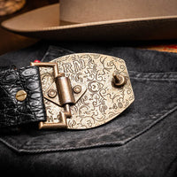 Close-up lifestyle image of black crocodile belt worn with casual outfit
