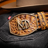 Close-up lifestyle shot of the IOWA mustard brown caiman belt worn with dark pants