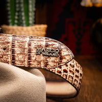 Man wearing Iowa Caiman belt with detailed Western buckle and tan casual pants outdoors.