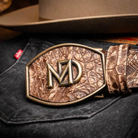 Close-up of belt buckle and texture on stone brown Iowa caiman crocodile leather belt worn with denim.