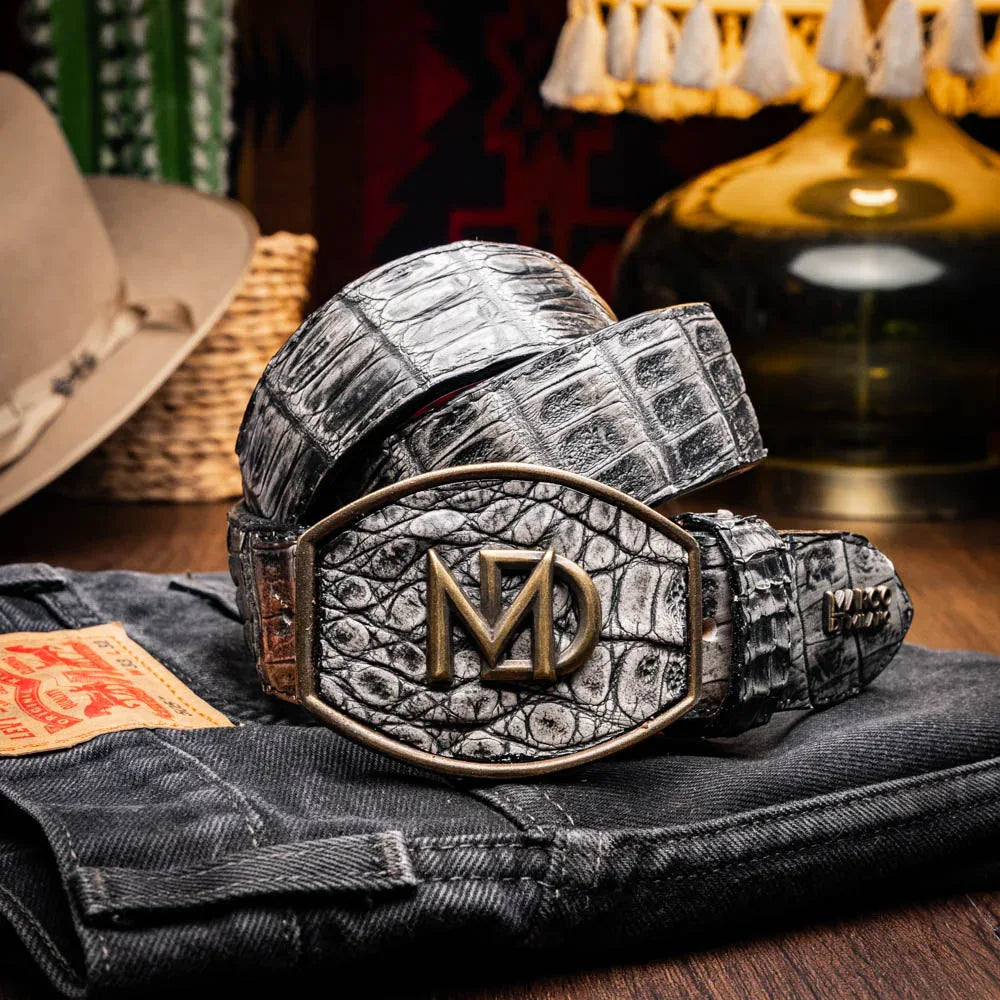 Lifestyle photo of person wearing gray caiman crocodile belt with jeans.