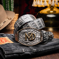 Lifestyle photo of person wearing gray caiman crocodile belt with jeans.