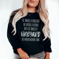 Black sweatshirt with 'It Takes A Vineyard To Homeschool A Child' text printed in white and red on the chest.