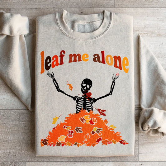 Sand color sweatshirt with a colorful autumn leaf design and Leaf Me Alone Fall text