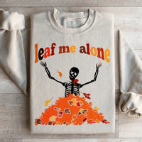 Sand sweatshirt showing a vibrant leaf pattern with warm fall colors and Leaf Me Alone Fall message