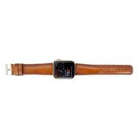 Leather Apple Watch band laid out with buckle and strap holes visible.