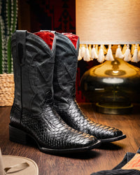 Lifestyle image of model wearing Missouri black Python cowboy boots outdoors.