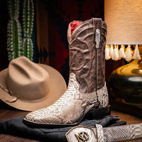 Model walking wearing Missouri Natural cowboy boots on natural terrain in cowboy style.