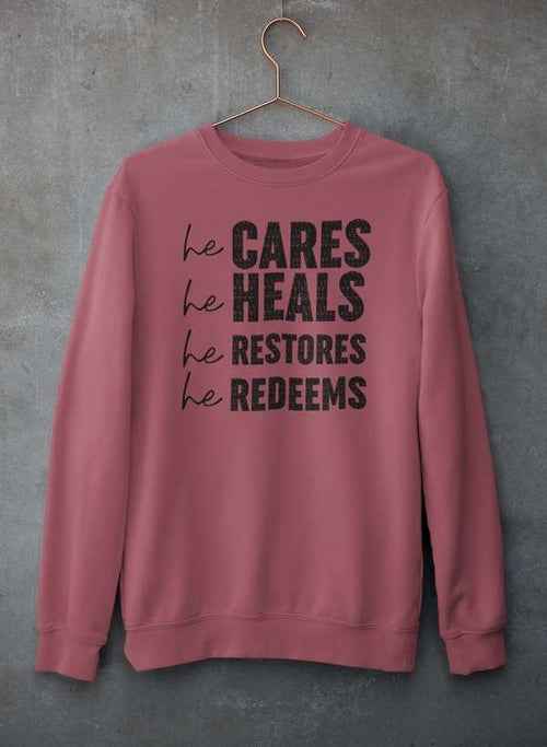 Gray sweatshirt featuring inspirational text hanging on hanger against textured concrete wall.