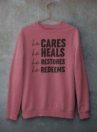 Gray sweatshirt featuring inspirational text hanging on hanger against textured concrete wall.