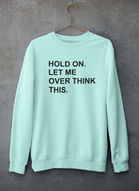 Crewneck sweatshirt hanging against a concrete wall, showcasing soft cotton/poly fleece material.