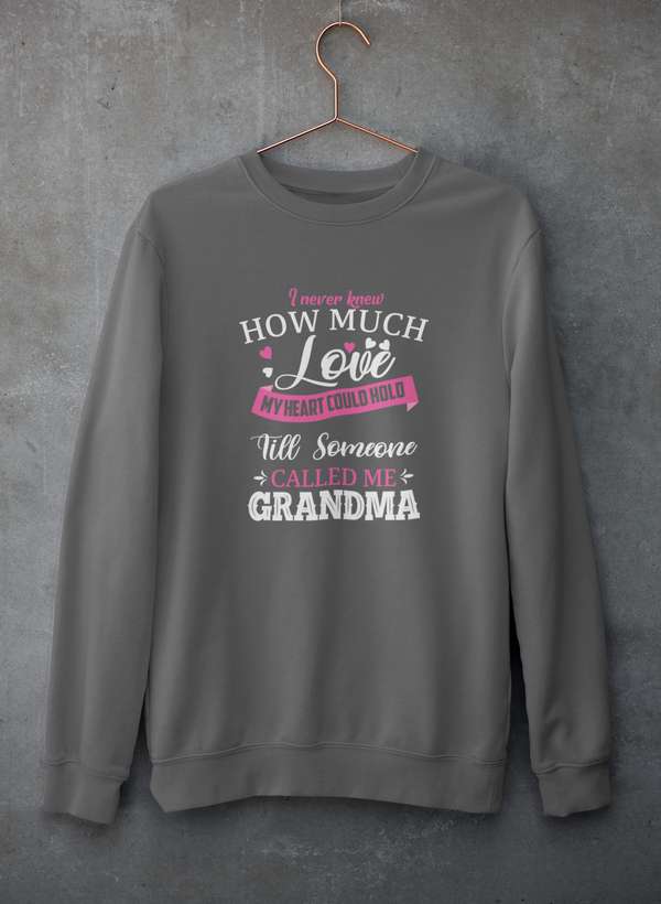 Gray crewneck sweatshirt hanging on a concrete wall with soft fleece lining visible at the collar.