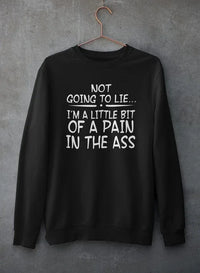 Close-up of light gray crewneck sweatshirt with text print hanging against rough concrete wall.