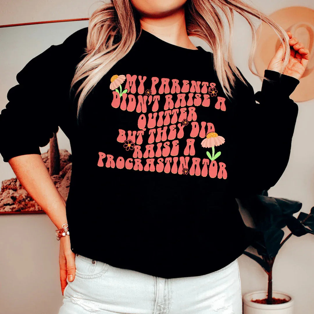 Black sweatshirt with white text saying 'My Parents Didn't Raise A Quitter' in bold font.