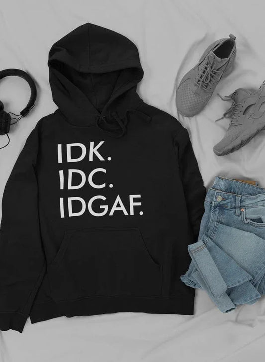 Pullover hoodie laid flat next to sneakers and jeans on white surface, styled casual outfit view.