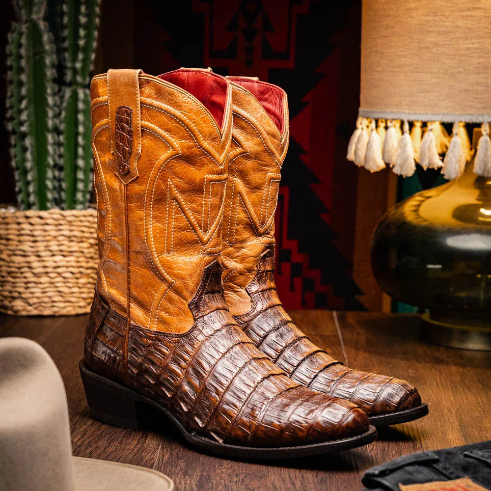 Lifestyle image of man wearing Phoenix Aged Maple cowboy boots outdoors on gravel path.