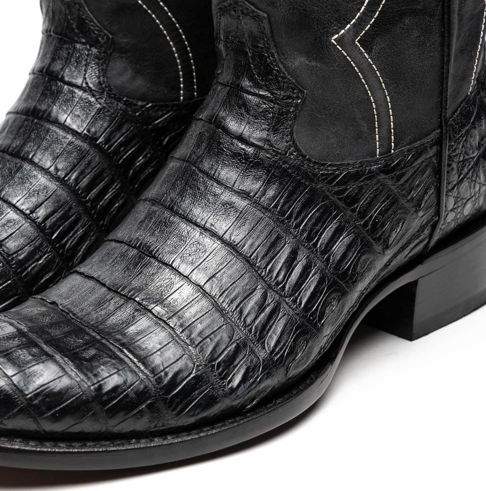 Black cowboy boot profile highlighting fine craftsmanship and textured caiman leather