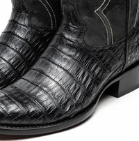 Black cowboy boot profile highlighting fine craftsmanship and textured caiman leather