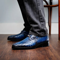 On-foot view of Ragusa navy caiman derby shoes highlighting texture and toe shape.