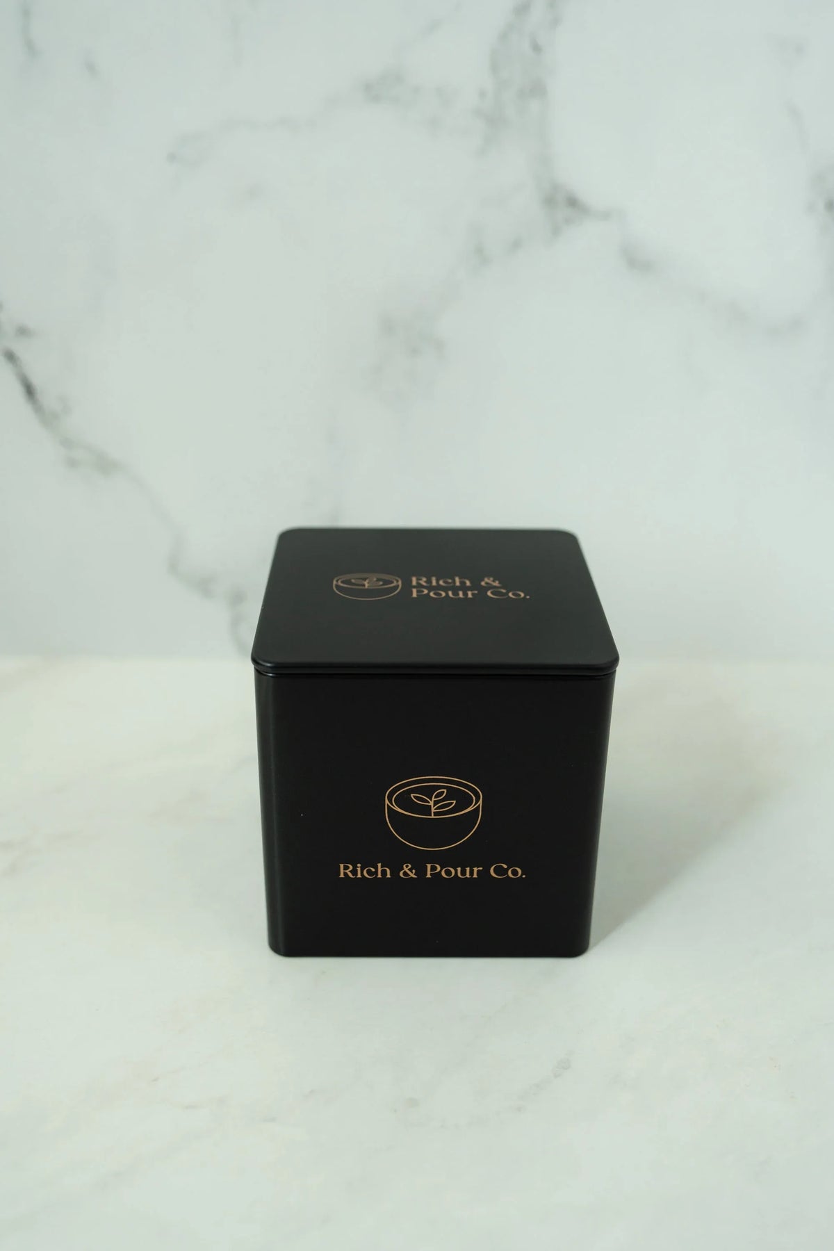 Overhead shot of three reusable tea storage tins arranged on a light-colored background.