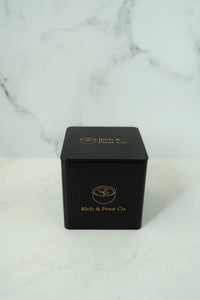 Overhead shot of three reusable tea storage tins arranged on a light-colored background.