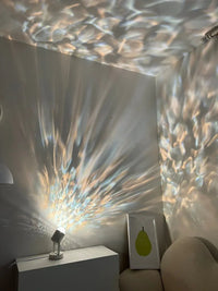 Ripple ambient night lamp creating soft, flowing wave patterns on dark wall in cozy room.