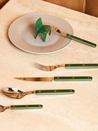 French dopamine cutlery set arranged on a wooden table showcasing polished silverware pieces.
