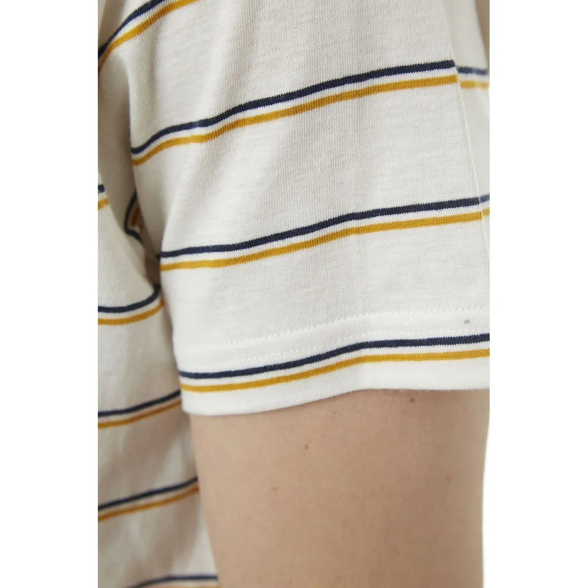 Model adjusting sleeve of Edgar Striped Tee showing fabric stretch and comfort.