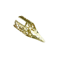 Side angle of a handcrafted brass Khmer ring resting on textured stone surface