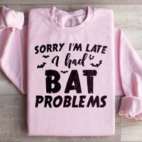 Light pink sweatshirt with Sorry I'm Late I Had Bat Problems text in white on front.