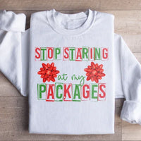 White sweatshirt displaying 'Stop Staring At My Packages' text in black on the chest area.