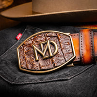 Lifestyle scene capturing the Texas Belt on a leather belt rack with natural wood background.