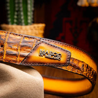 Model styling the Texas Belt with jeans and boots in rustic setting.