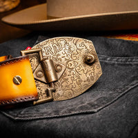 Man showing the textured surface of the Texas Belt in mustard brown worn with belt loops.