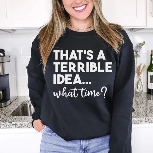 Close-up of peach sweatshirt showing 'That's A Terrible Idea' graphic on soft fabric.