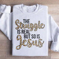 White sweatshirt printed with black text reading 'The Struggle Is Real But So Is Jesus'.