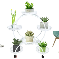 Top view of black metal plant stand featuring six pots each with vibrant houseplants.