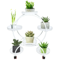 Black metal six-tier circular stand displaying houseplants in various pots against white background.